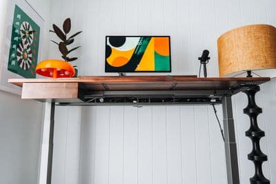 a desk with a lamp and a painting on it