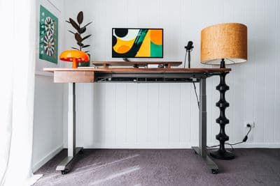 a desk with a lamp and a painting on it