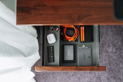 a table with a phone, charger, charger and other items