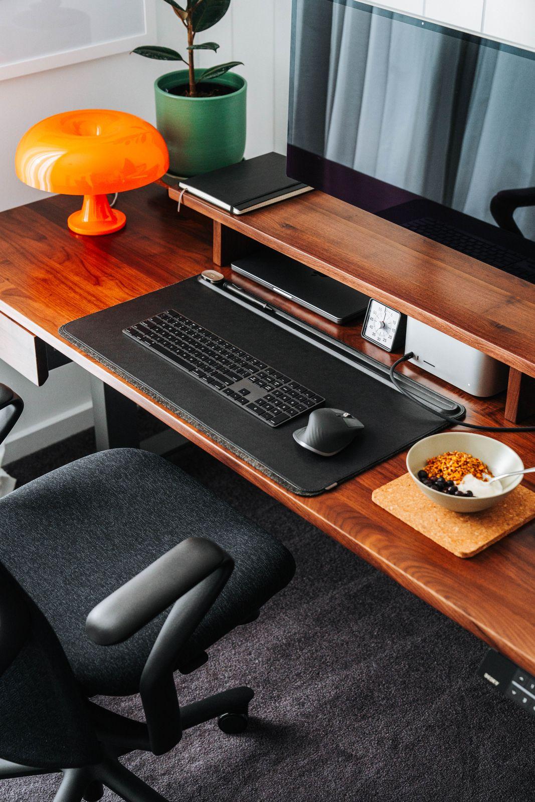 a desk with a computer and a bowl of cereal