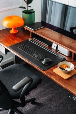 a desk with a computer and a bowl of cereal