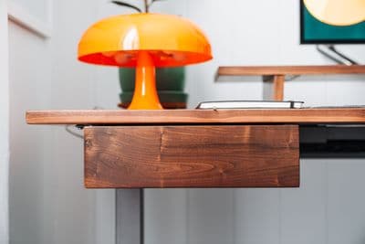 a desk with a lamp and a laptop on it