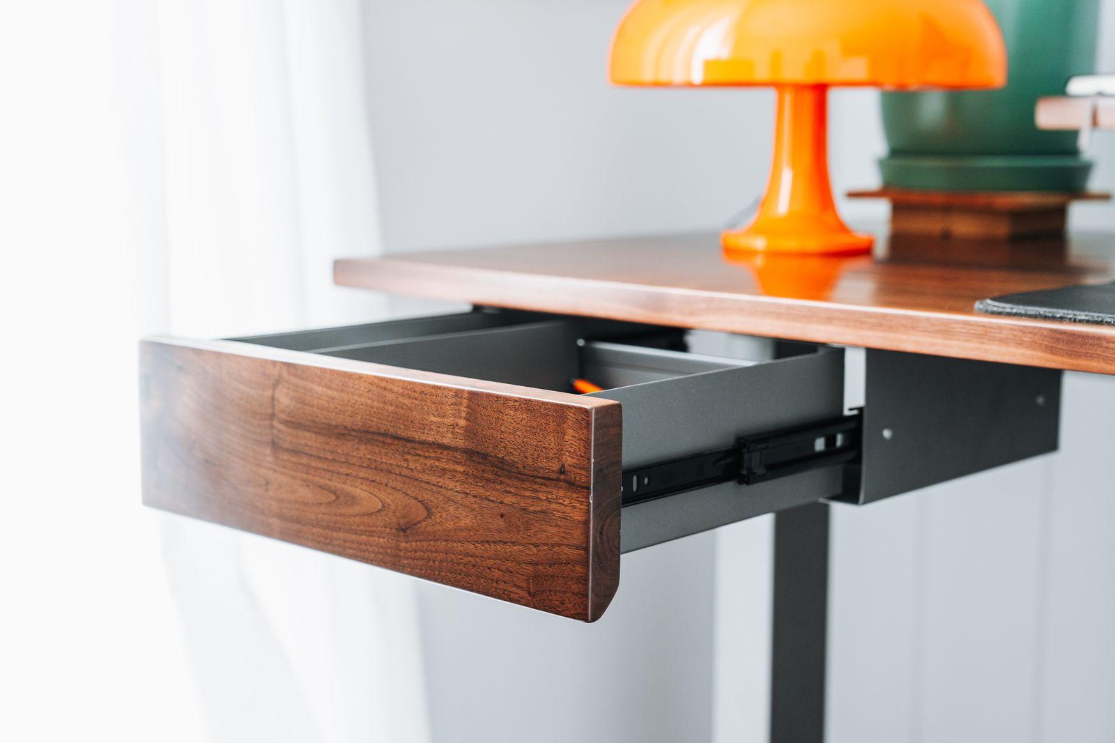 a desk with a laptop and a lamp on top of it