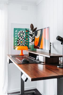 a desk with a computer monitor and a mouse