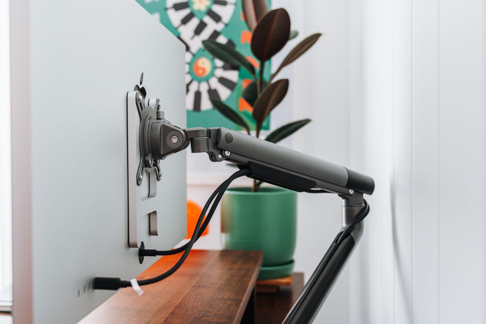 a desk with a monitor and a microphone attached to it