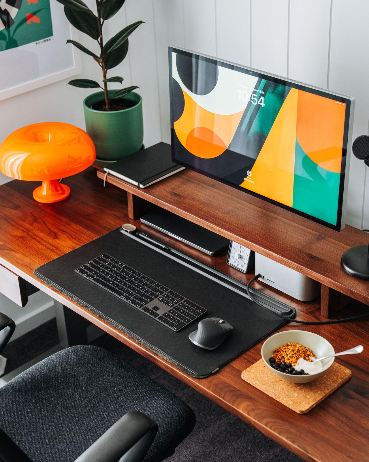 a desk with a computer and a bowl of cereal