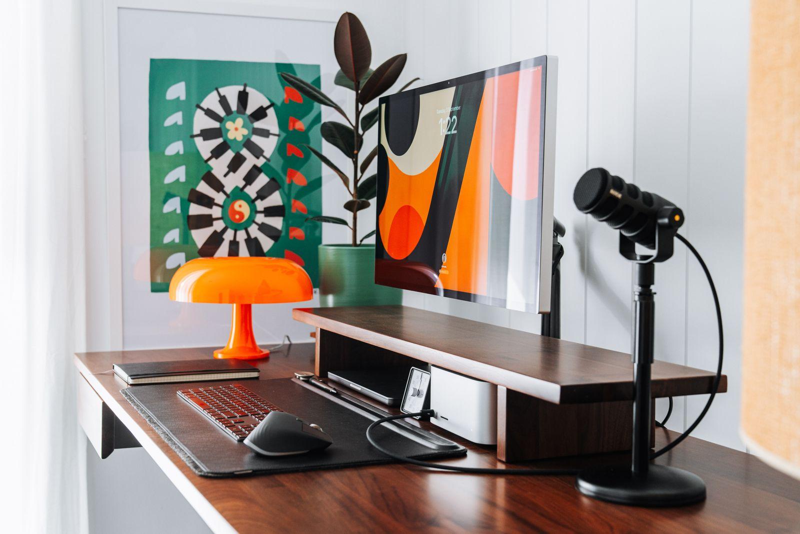 a desk with a laptop and a lamp on it