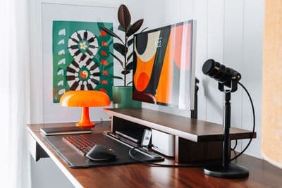 a desk with a laptop and a lamp on it