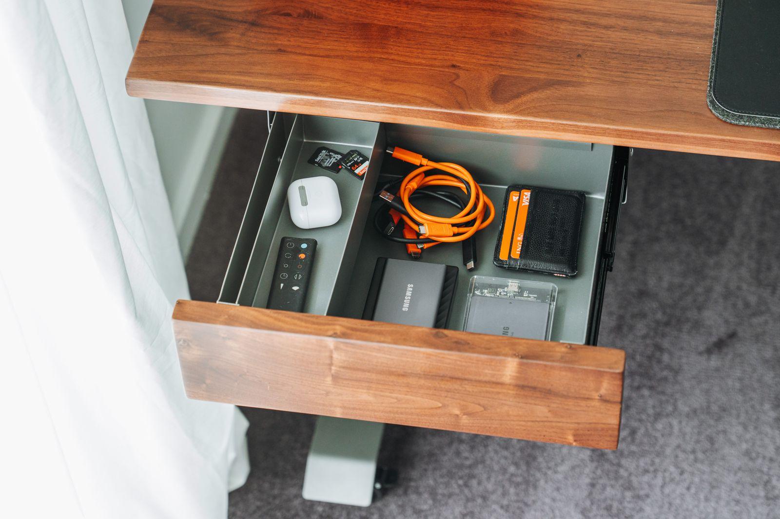 a drawer with a cord and a charger in it
