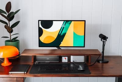 a desk with a monitor, keyboard and mouse on it
