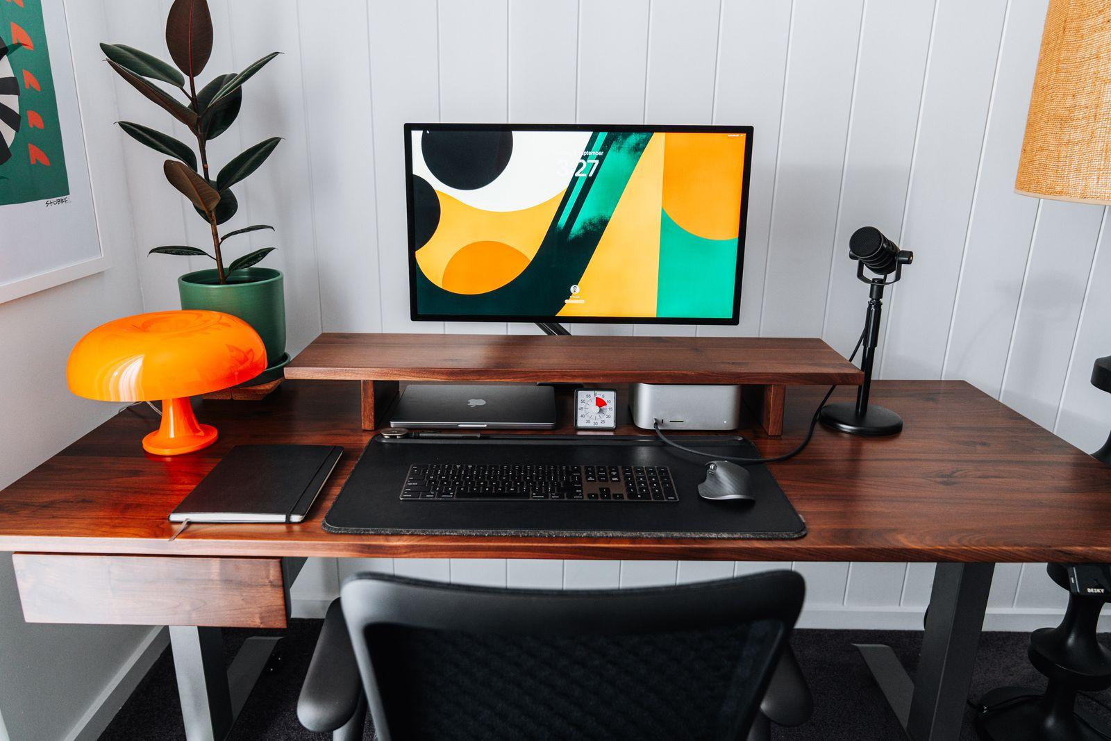 a desk with a computer and a lamp on it