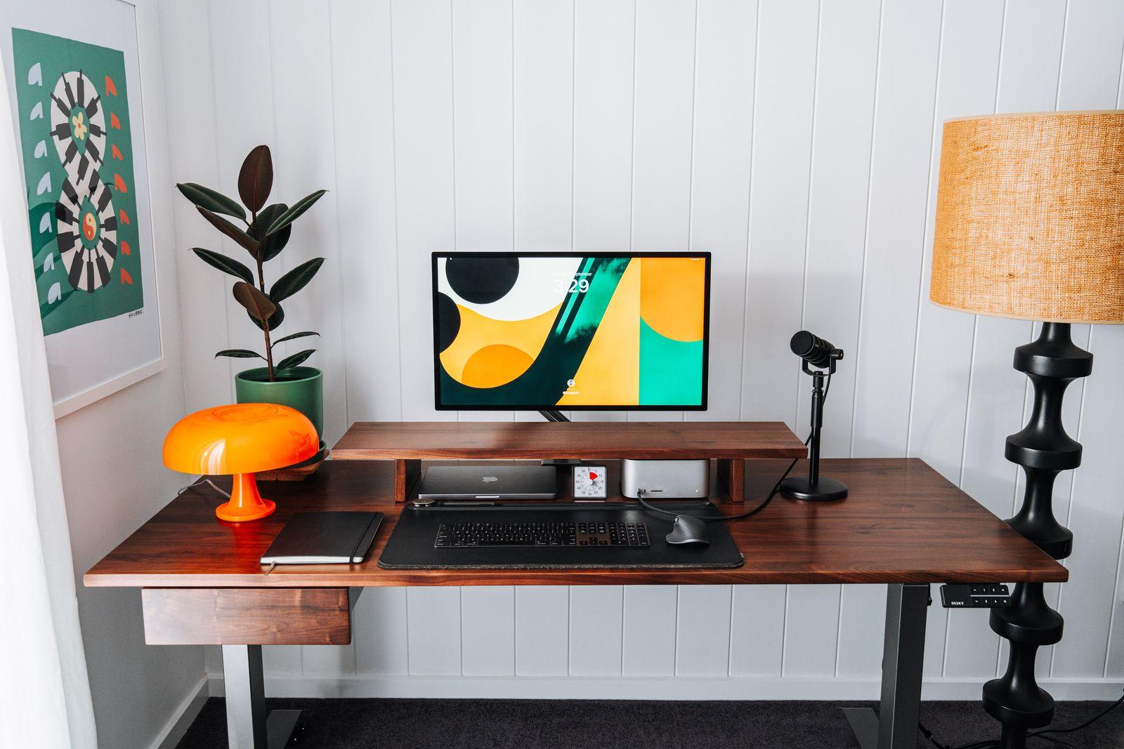 a desk with a computer and a lamp on it