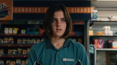 a woman in a green shirt standing in a store