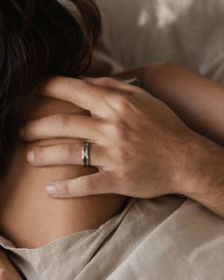 a man holding a woman's hand with a wedding ring