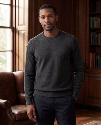 a man standing in front of a brown chair