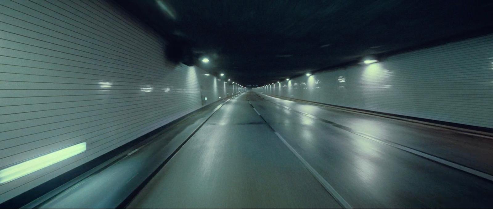 a very long tunnel with lights at the end
