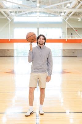 a man standing on a basketball court holding a basketball