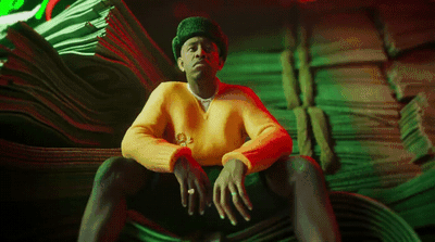 a man sitting in a chair with a hat on