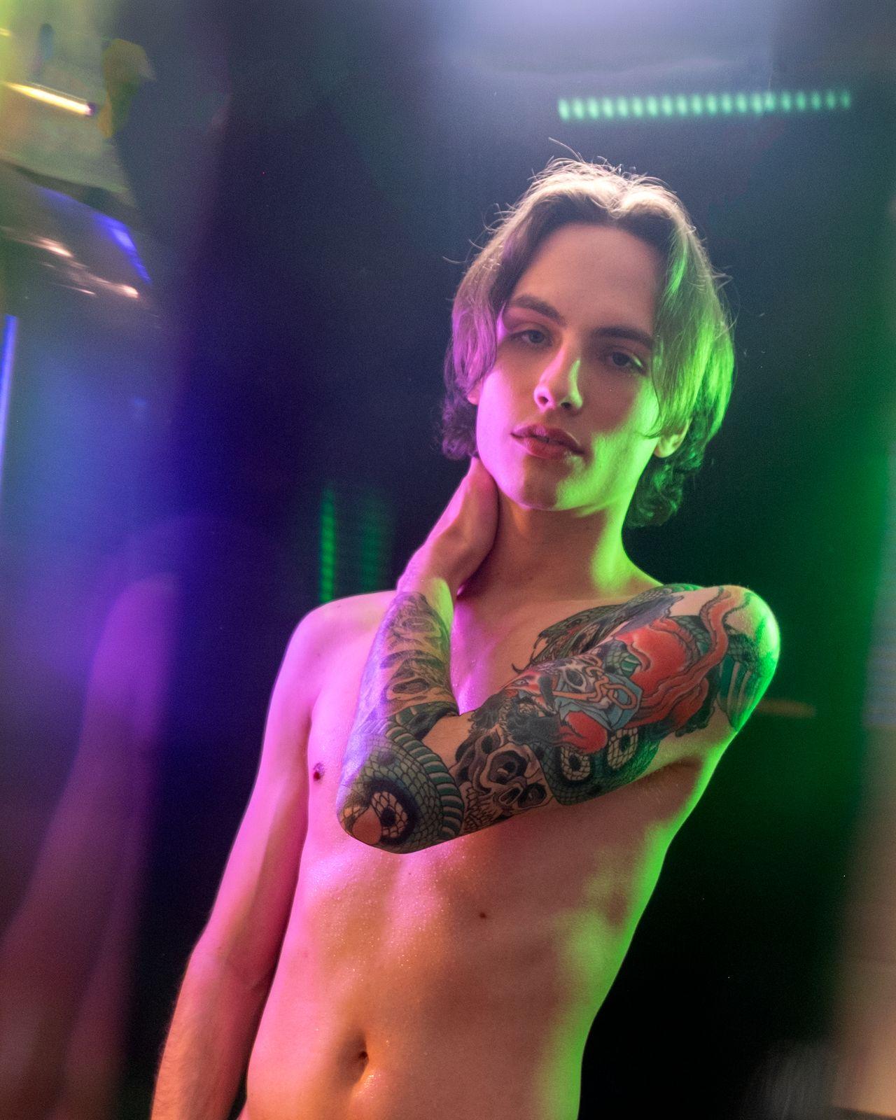 a man with a tattoo on his arm posing for a picture