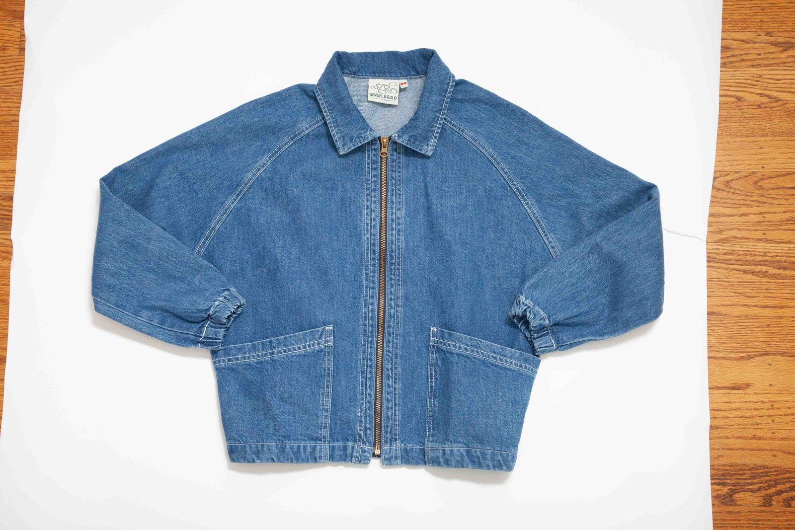 a blue jean jacket sitting on top of a wooden table