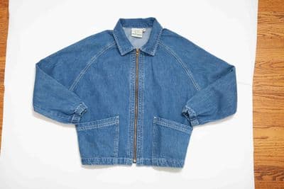 a blue jean jacket sitting on top of a wooden table
