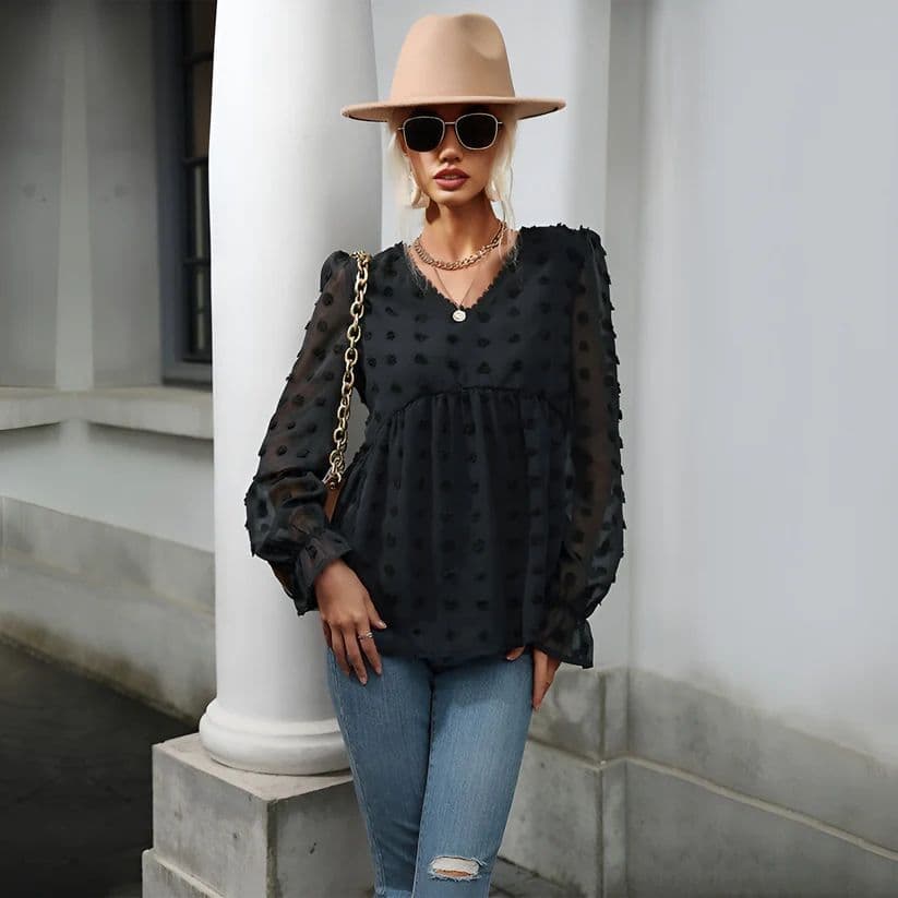 a woman standing next to a pillar wearing a hat and sunglasses