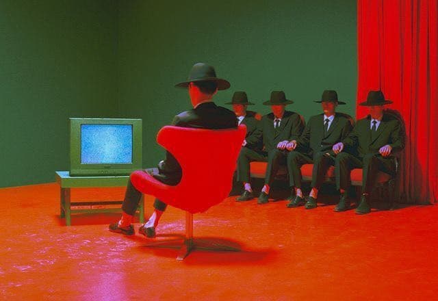 a group of men sitting in front of a tv