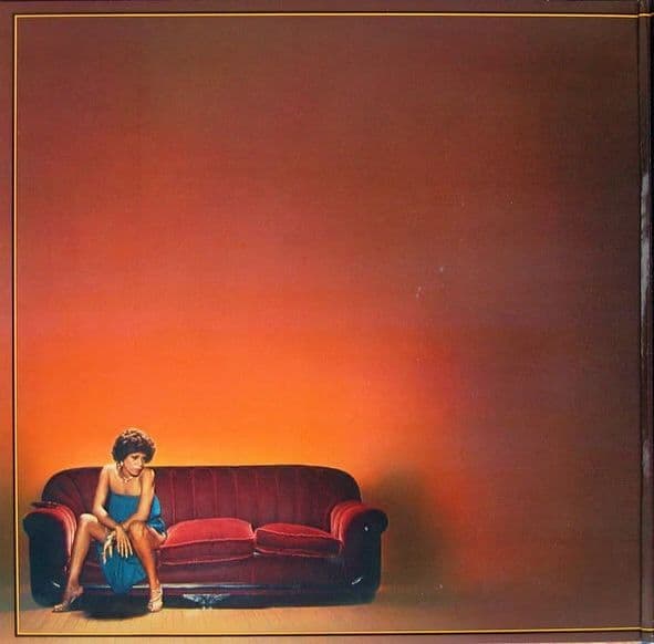 a woman sitting on top of a red couch