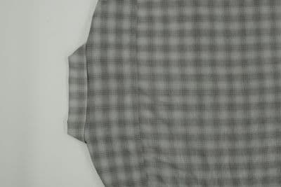 a black and white checkered shirt hanging on a wall