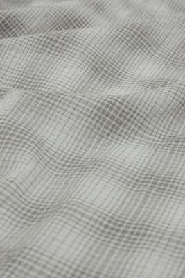 a close up of a bed with a checkered comforter