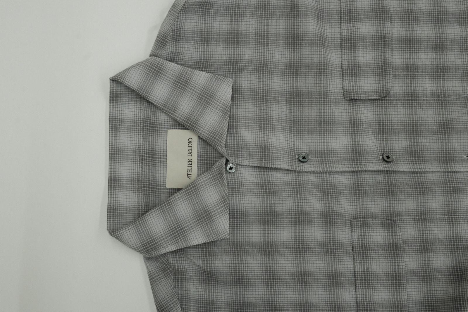 a gray and black checkered shirt with a tag on it