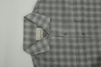 a gray and black checkered shirt with a tag on it