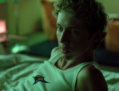 a woman in a tank top laying on a bed