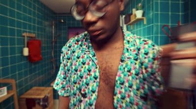 a man in a colorful shirt in a bathroom