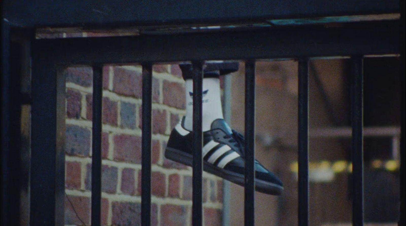 a pair of black and white shoes hanging on a fence