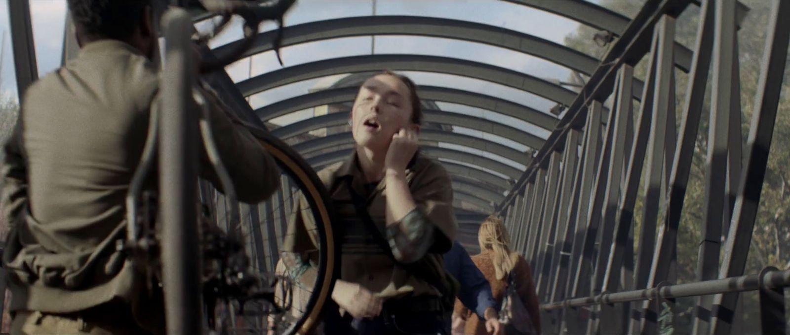 a woman talking on a cell phone on a bridge