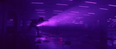 a person standing in a room with a purple light