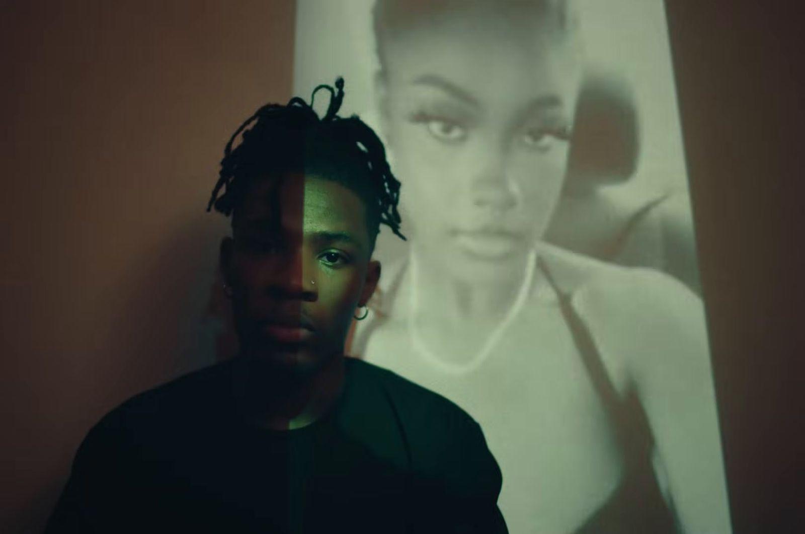 a man standing in front of a picture of a woman