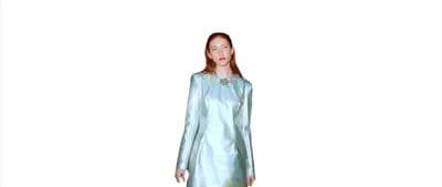 a woman in a blue dress standing in front of a white background