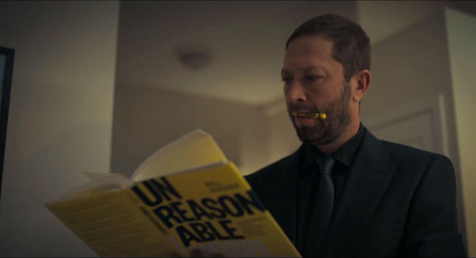 a man in a suit is reading a book