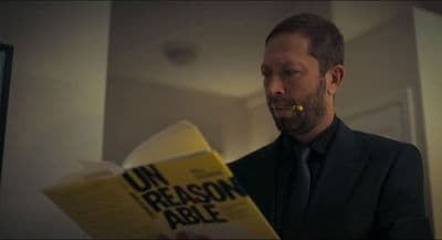 a man in a suit is reading a book