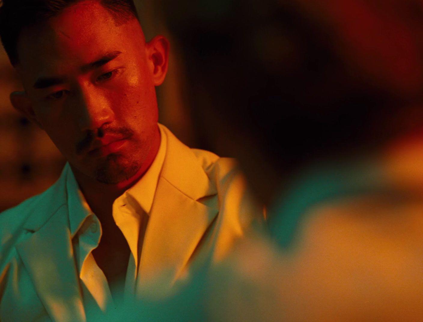 a man in a white suit looking at his cell phone