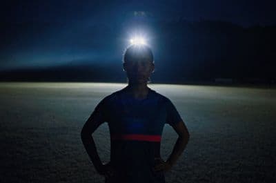 a person standing in a field with a light on their head