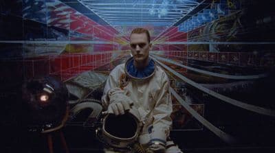a man in a space suit holding a helmet