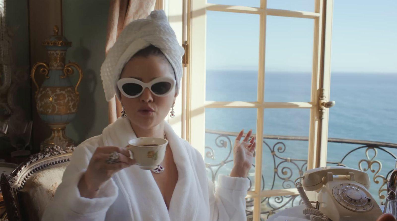 a woman in a bathrobe holding a cup of coffee