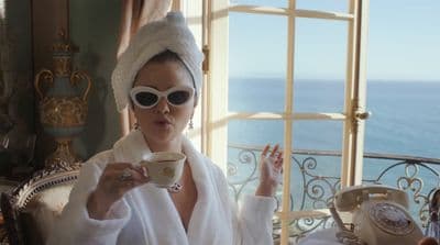 a woman in a bathrobe holding a cup of coffee