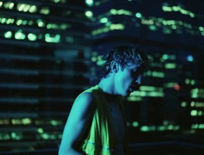 a man standing in front of a city at night