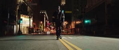 a man riding a skateboard down a street at night