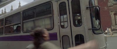 a woman is walking by a bus on the street
