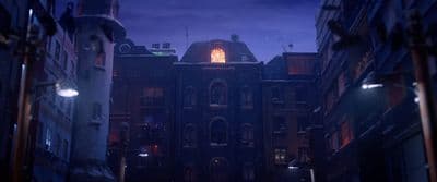 a city street at night with a building lit up